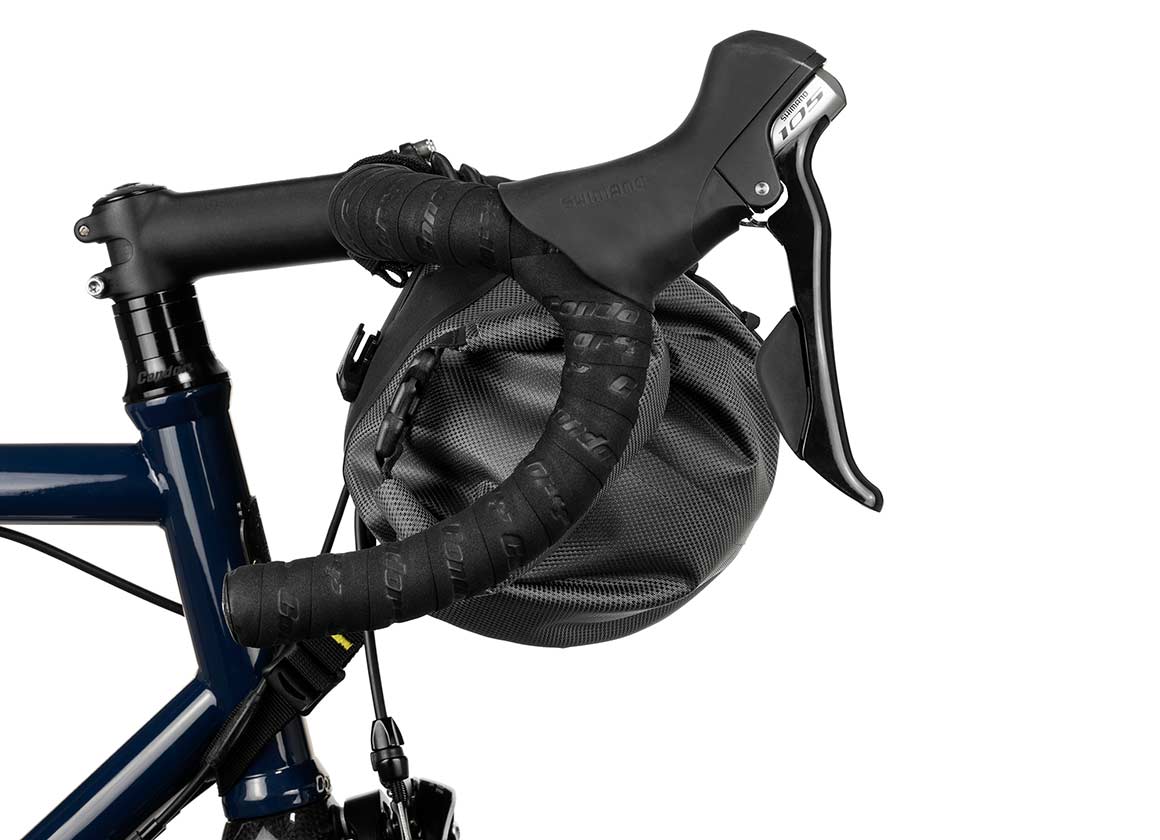 Apidura Handlebar Bag on front of handlebars from the side