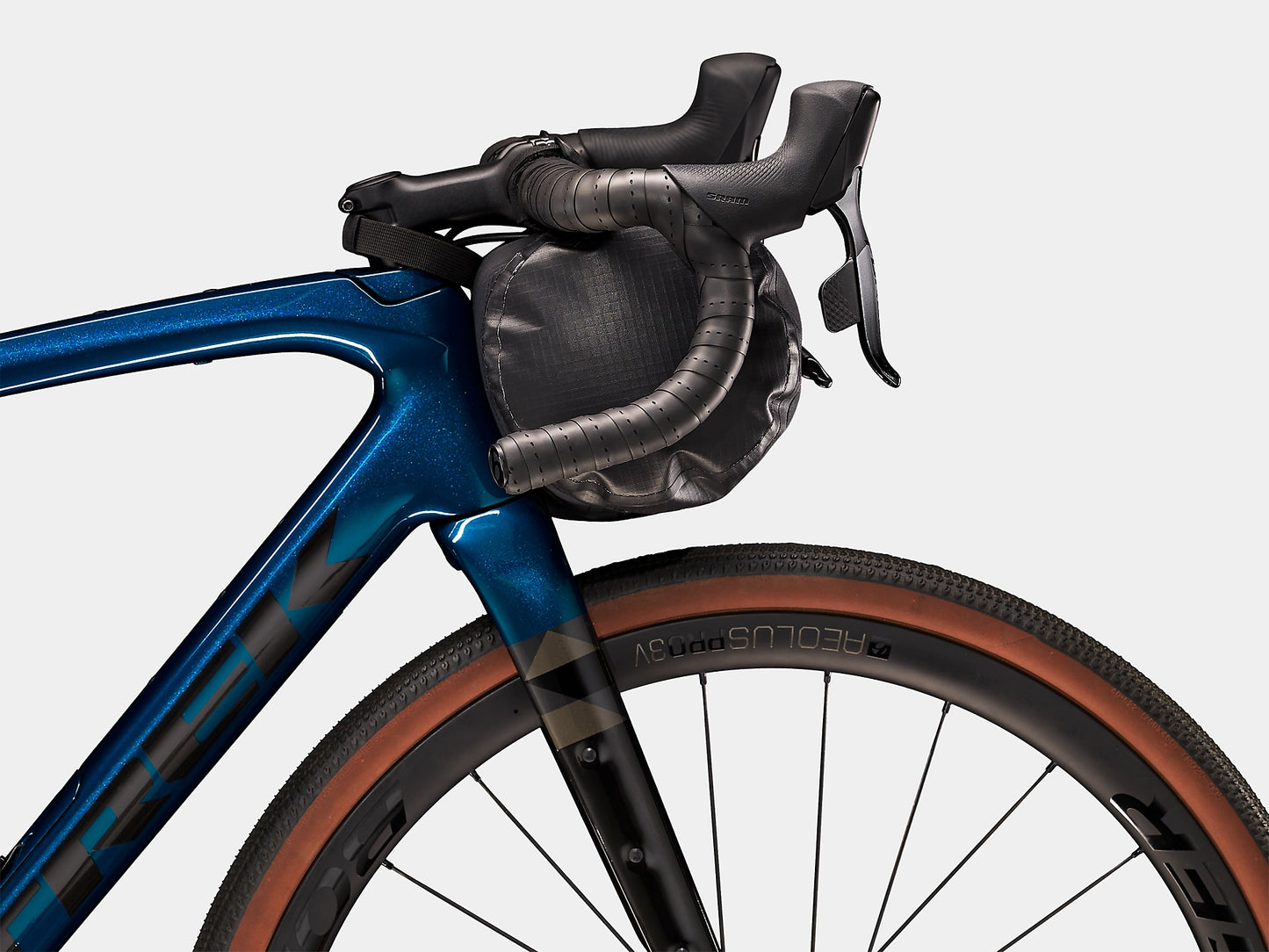 Bontrager Adventure Handlebar Bag 9L on the front of a bikes handlebars from the side with a white background